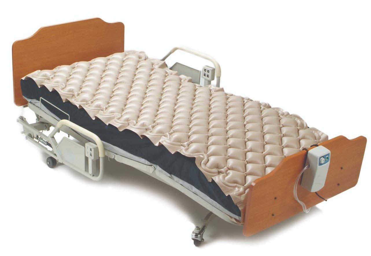 Alternating pressure mattress topper installed on a hospital bed.