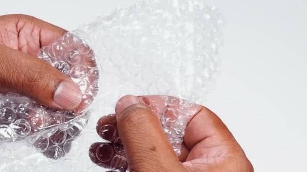 Hands popping bubble wrap.