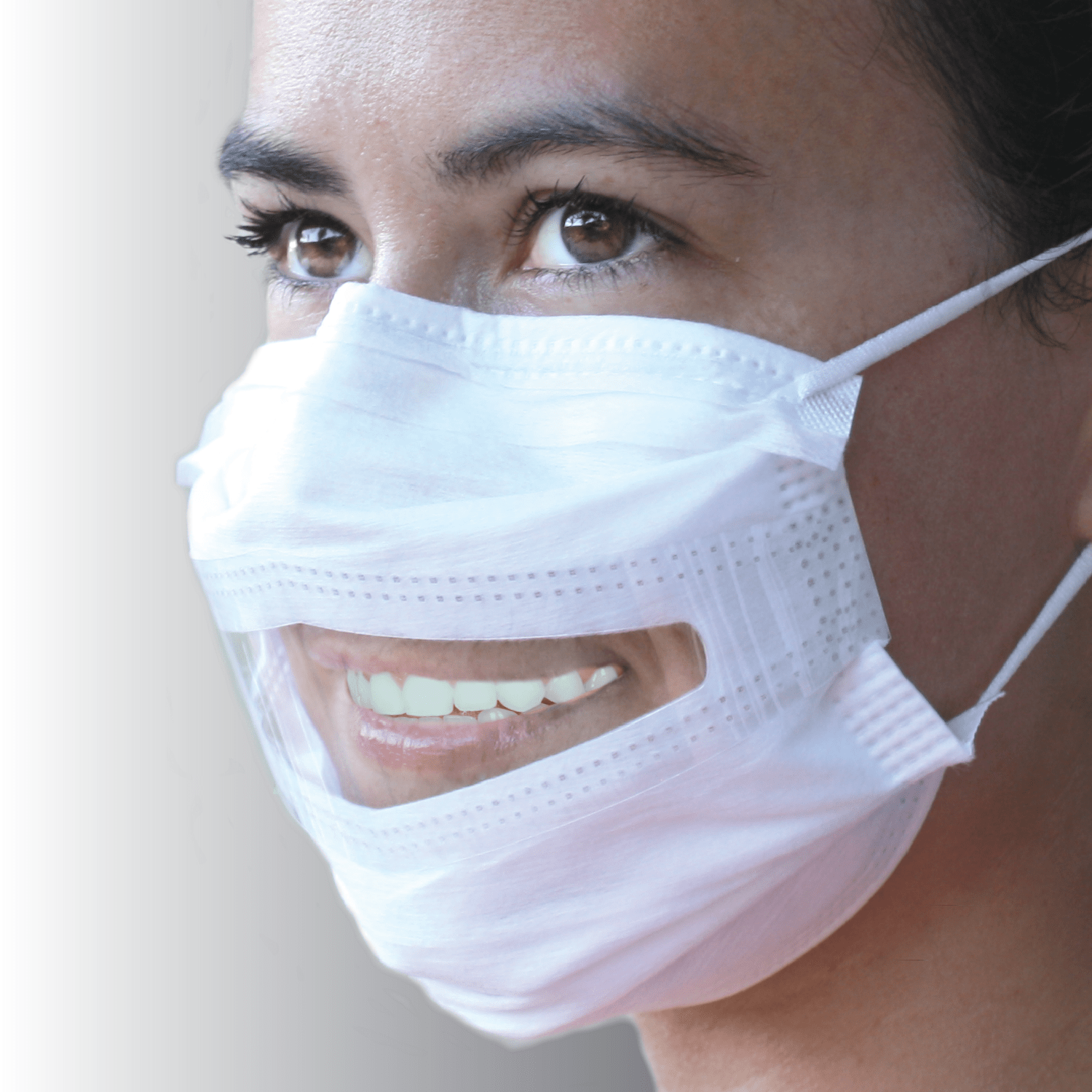 A woman smiles wearing a surgical mask with a window.