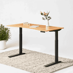 A height-adjustable desk with a vase of flowers.
