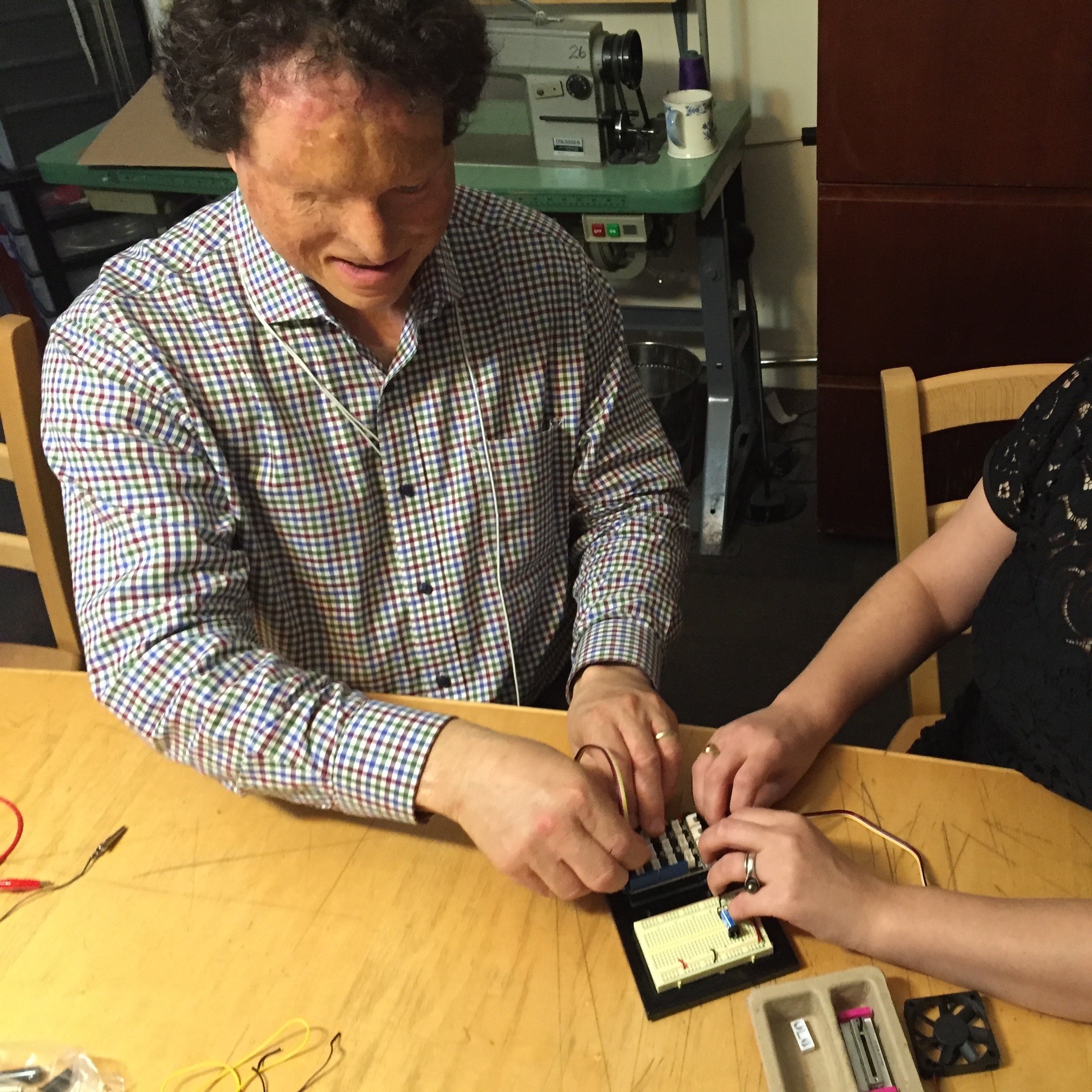 Un homme malvoyant travaille avec une femme pour utiliser Arduino