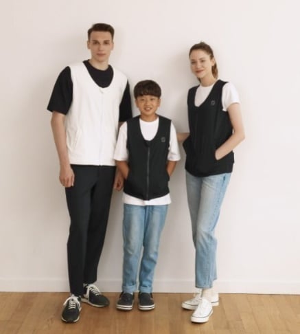 A young man, woman, and child wearing huggy smart vests.