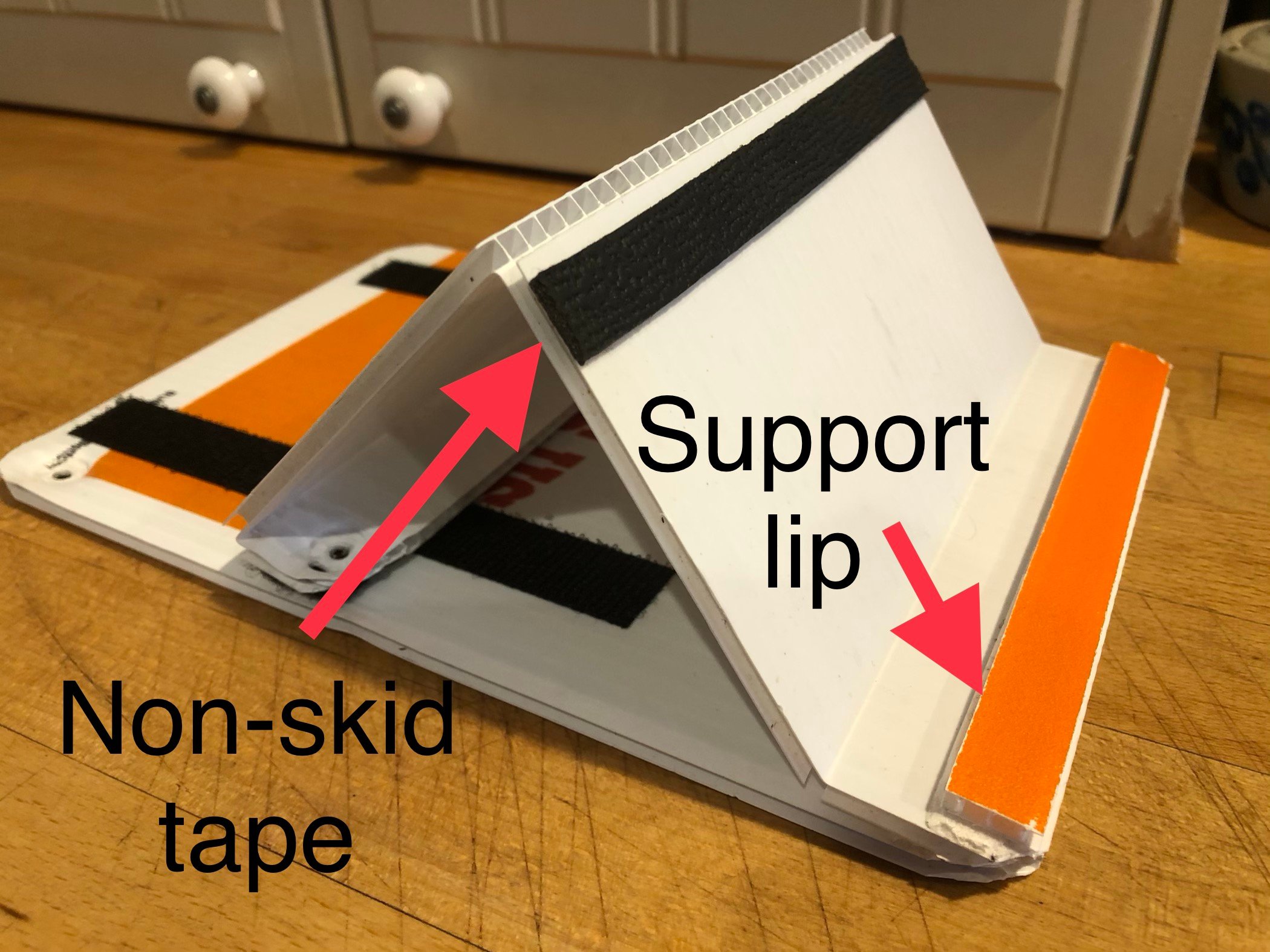 Corrugated plastic iPad stand with non-skid tape and support lip labeled.