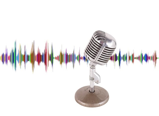 Un micrófono vintage con un colorido patrón de ondas sonoras de fondo.