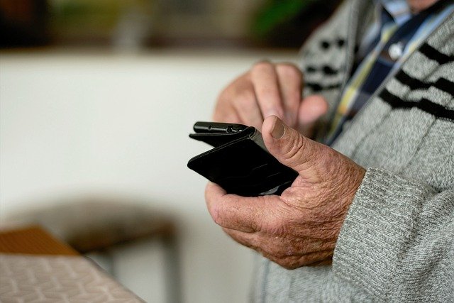 Then hands of a senior holding a mobile phone.