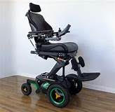 A power wheelchair with a seat elevator and head support.