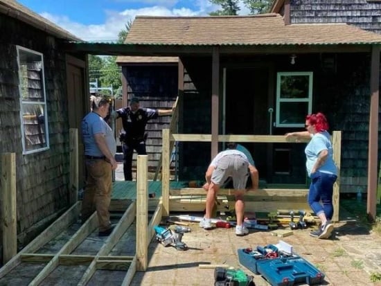 Volunteers build a wheelchair accessible ramp for a house.
