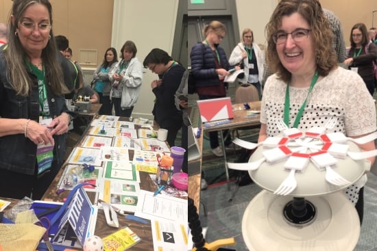Two smiling women with their materials in a busy exhibit hall. Schoonover overlooks a table of printed instructions and materials for making art. Driscoll holds a rotating elevated plate equipped with forks pointing outward like spokes.