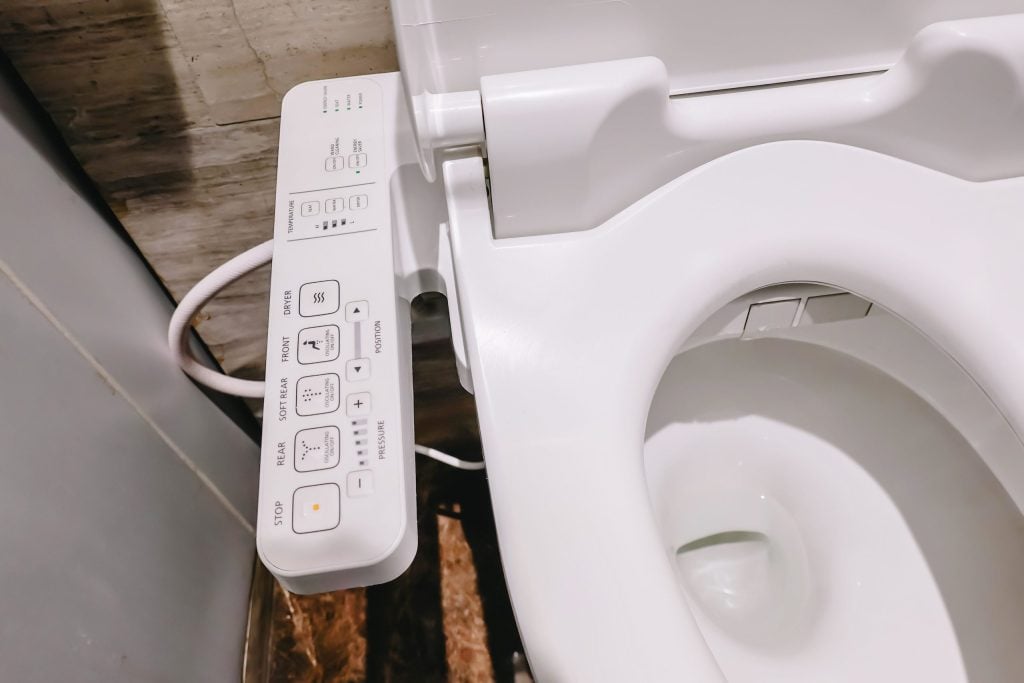Shows bidet controls with buttons for stop, rear, dryer, temperature, pressure, and position.soft rear, front
