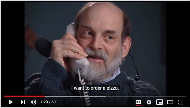 Screenshot of a YouTube video shows an older man speaking into a telephone handset with the caption 