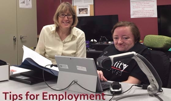 Conseils pour l'emploi : montre deux femmes derrière un bureau utilisant des technologies d'assistance, dont l'une est en fauteuil roulant.