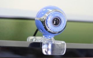 Gros plan d'une webcam posée sur le bord d'un moniteur.
