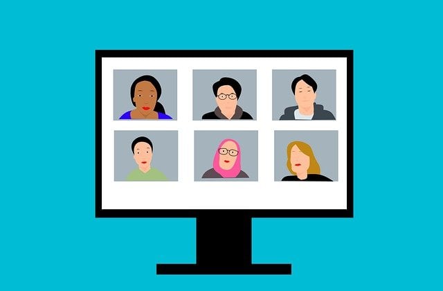 Monitor displays six people of diverse ethnicities video conferencing.