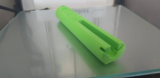 A 3D printed tube with a long slot and a hook groove. Worm Hooker is printed on one half.