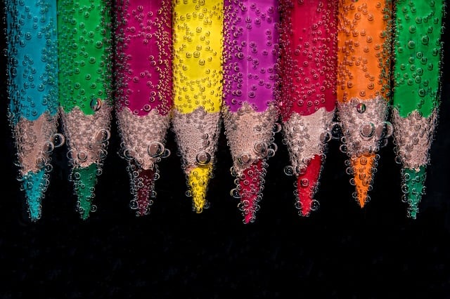 A rainbow of colored pencil tips underwater